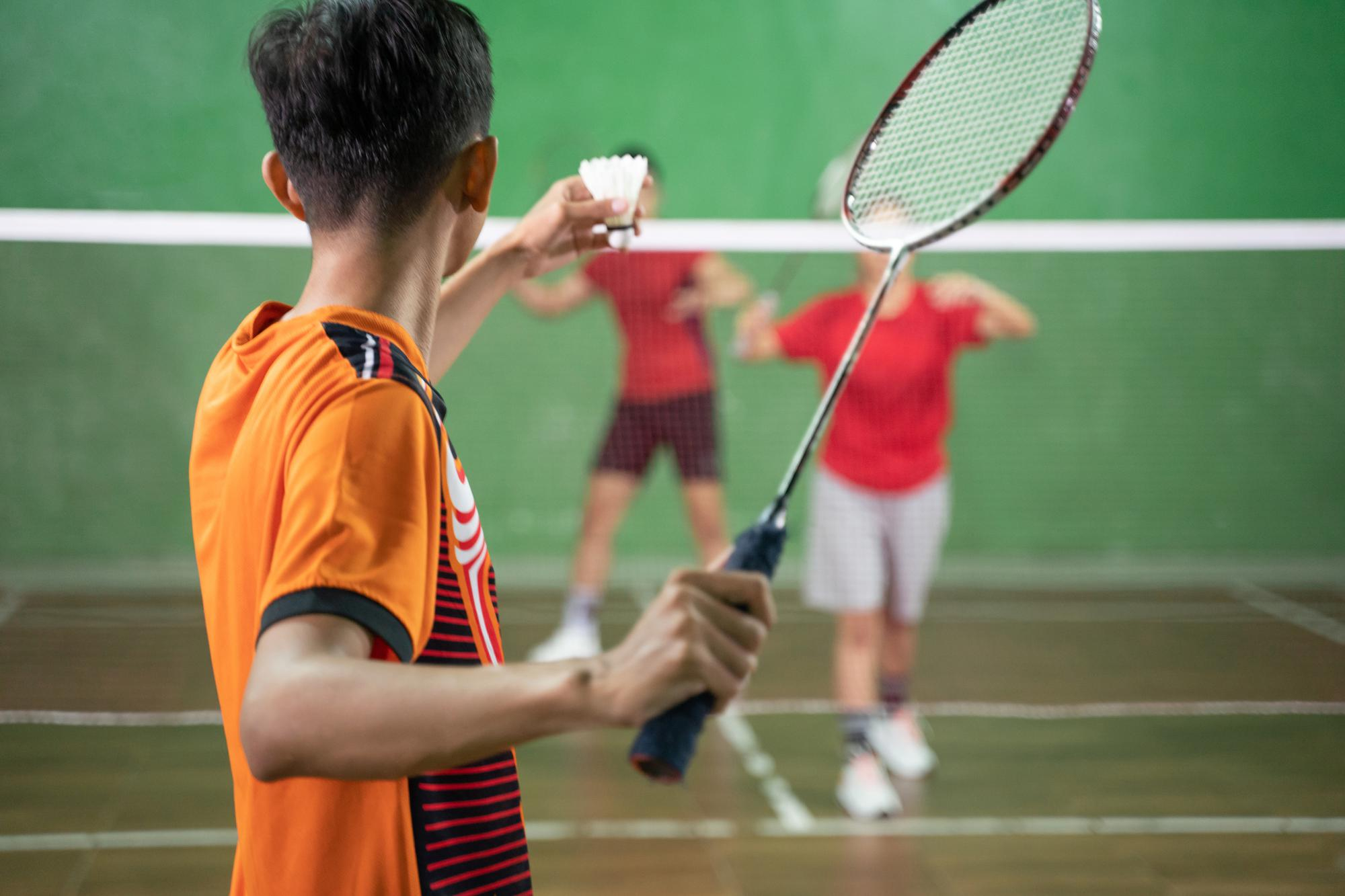 badminton-player-orange-uniform-ready-serve